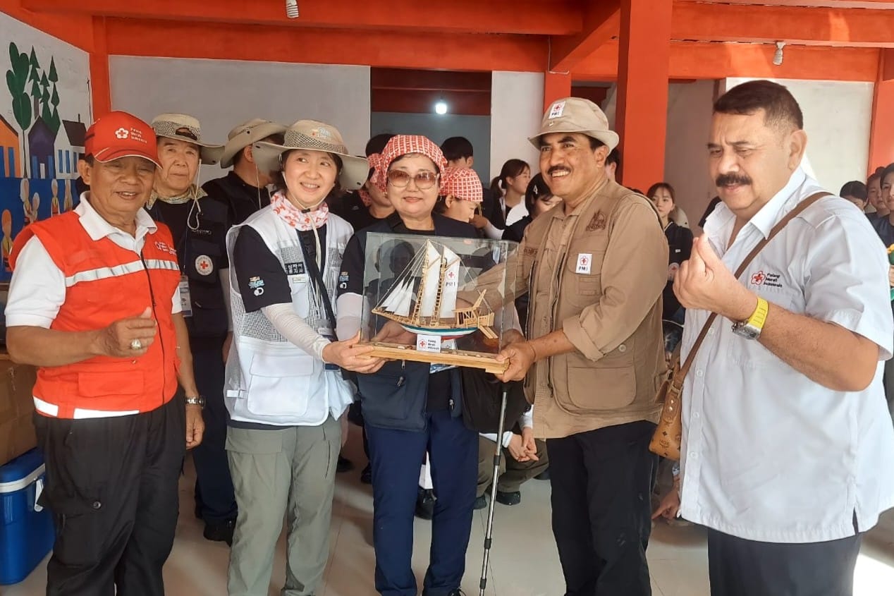 Pengurus Pusat PMI Marsekal Muda TNI (Purn) Tri Bowo Budi Santoso menyerahkan cendera mata berupa miniatur kapal layar ke perwakilan Palang Merah Korea dalam kunjungan hari ke-tiga di Pulau Untung Jawa, Jumat (21/2/2025).