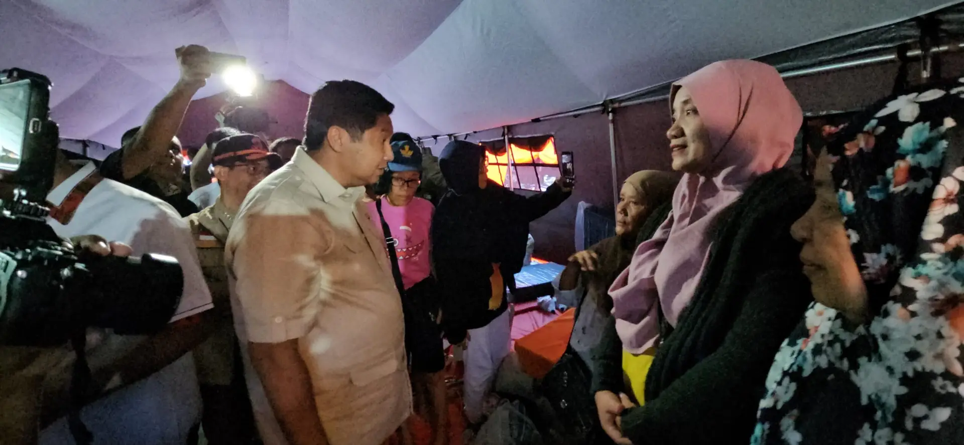 Menteri PKP saat berbincang dengan salah satu korban banjir ditenda pengungsian ( foto: birkom PKP/ Ristyan )