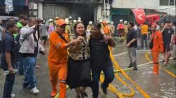 Petugas pemadam saat mengevakuasi korban kebakaran (foto = Diah/Spektroom)