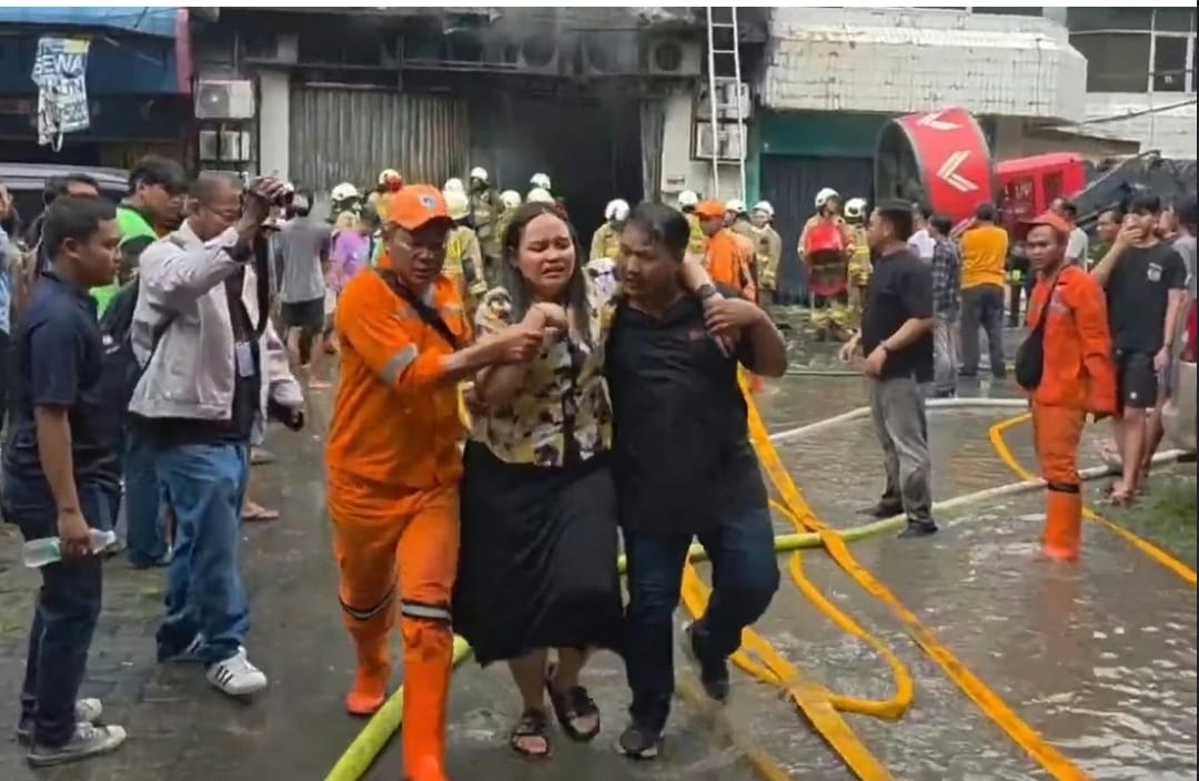 Petugas pemadam saat mengevakuasi korban kebakaran (foto = Diah/Spektroom)