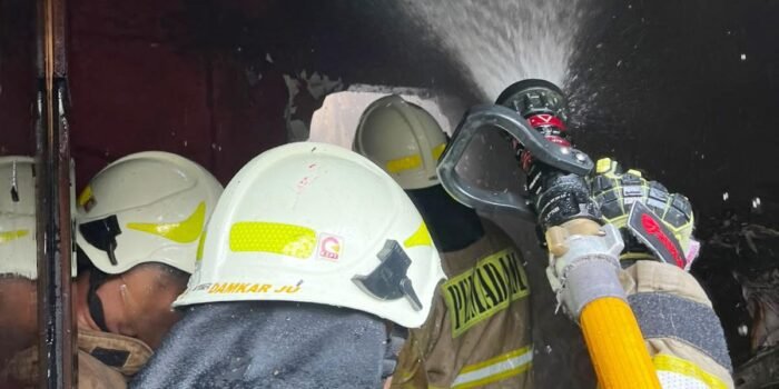 Petugas pemadam kebakaran saat melakukan penanganan kebakaran rumah di Papanggo.